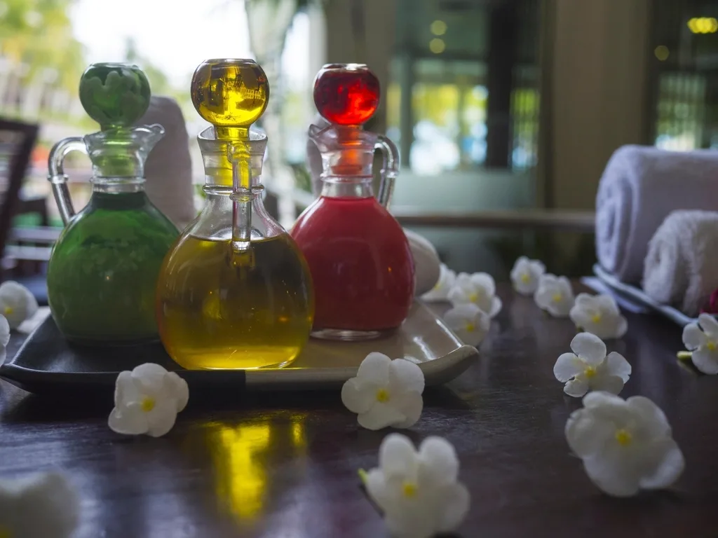 Colorful botanical oils in glass bottles with white flowers