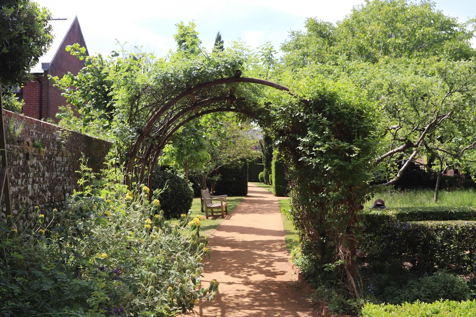 Rose-covered garden arch over a stone path